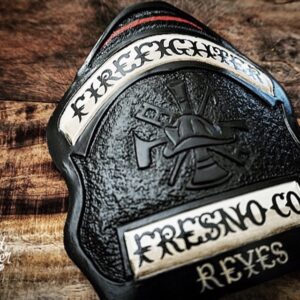 A hard-carved and hand-painted fire helmet shield by Smoked Leather.