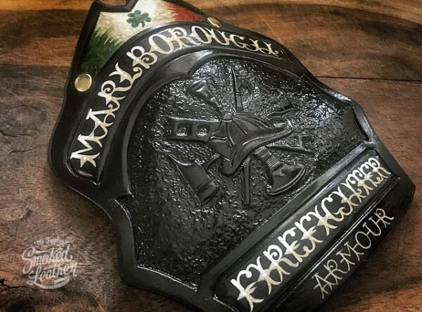 A hard-carved and hand-painted fire helmet shield by Smoked Leather.